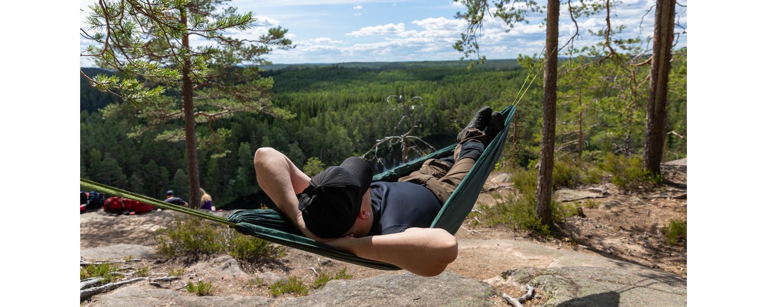 A man lying in a hammock on the top of Olhava rock in Repovesi National Park